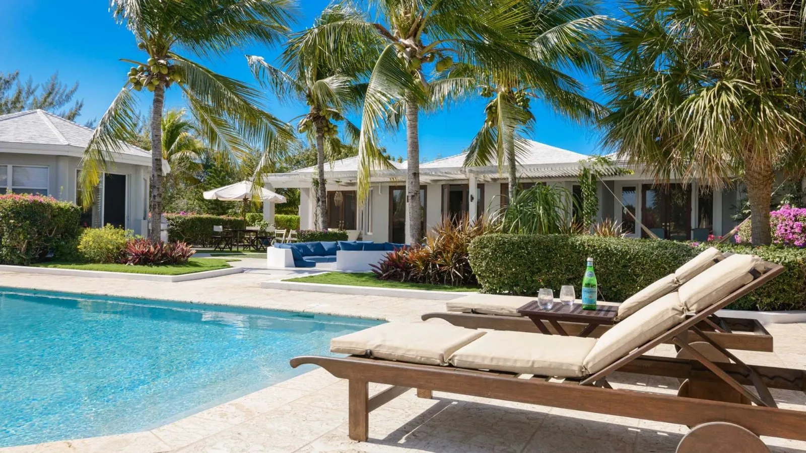 Pool and terrace framed by palms and bougainvillea at Below Deck villa.